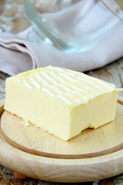 Manteiga amarela fresca num suporte de madeira, produtos biológicos — Fotografia de Stock