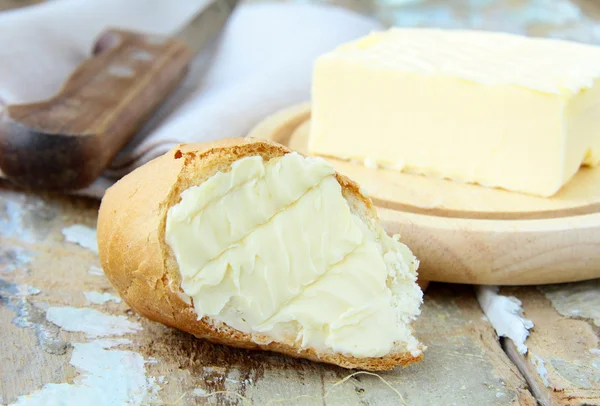 Beurre jaune frais et pain frais sur une table en bois — Photo