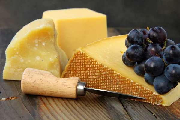 木製の黒い背景のブドウとチーズの盛り合わせ — ストック写真