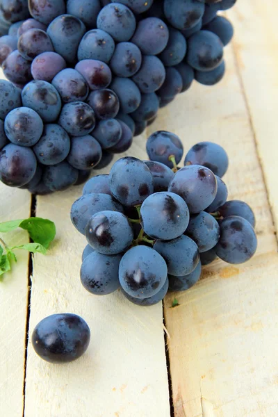 stock image Brush black sweet grapes in a basket on wooden table