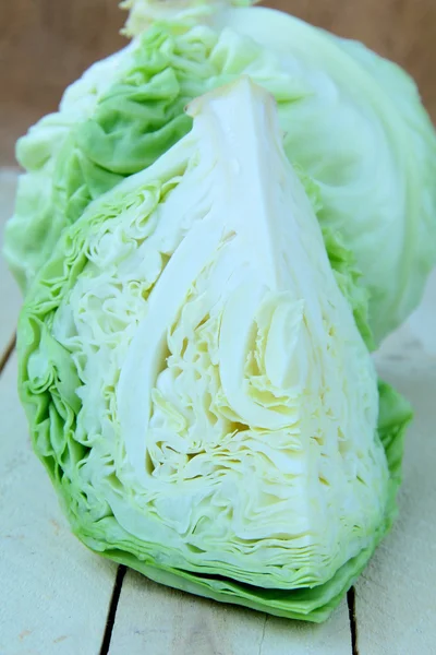 Fresh young green cabbage on a wooden table — Stock Photo, Image