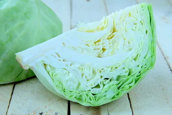 Fresh young green cabbage on a wooden table — Stock Photo, Image