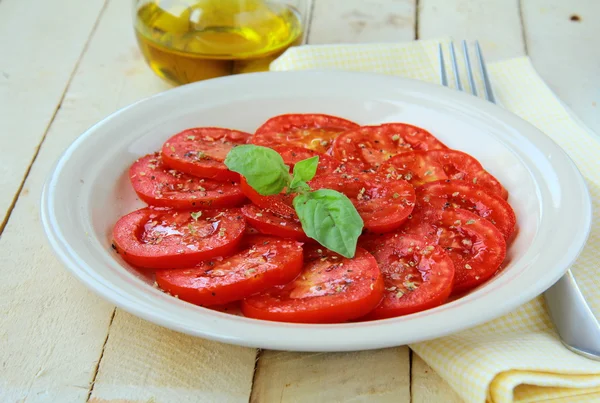 Salada de tomates frescos e azeite em uma mesa de madeira — Fotografia de Stock