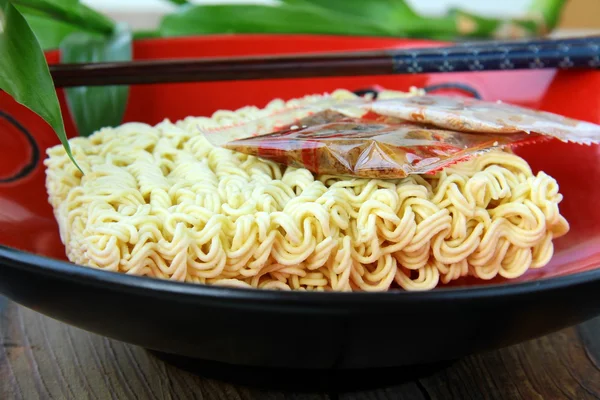 Fideos asiáticos instantáneos comida rápida con palillos en una taza roja — Foto de Stock
