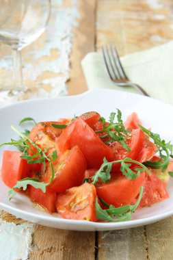 roka rustik tarzı ahşap bir masa üzerinde olgunlaşmış domates salatası