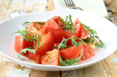 roka rustik tarzı ahşap bir masa üzerinde olgunlaşmış domates salatası