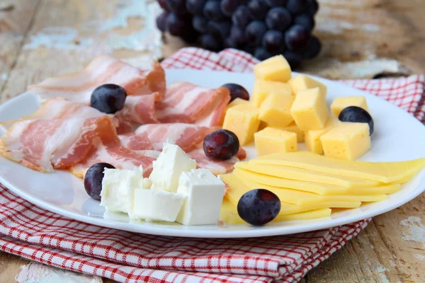 Piatto di formaggio snack con uva e pancetta affumicata — Foto Stock