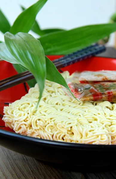 Fideos asiáticos instantáneos comida rápida con palillos en una taza roja — Foto de Stock