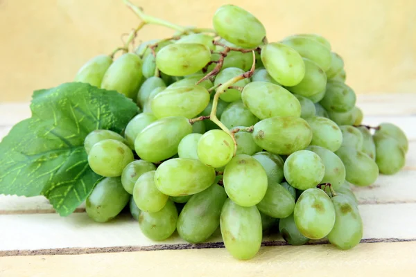 Tak van groene druiven op een houten achtergrond — Stockfoto