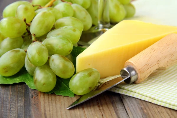 Still-life with green grapes and a piece of cheese with a knife — Stock Photo, Image