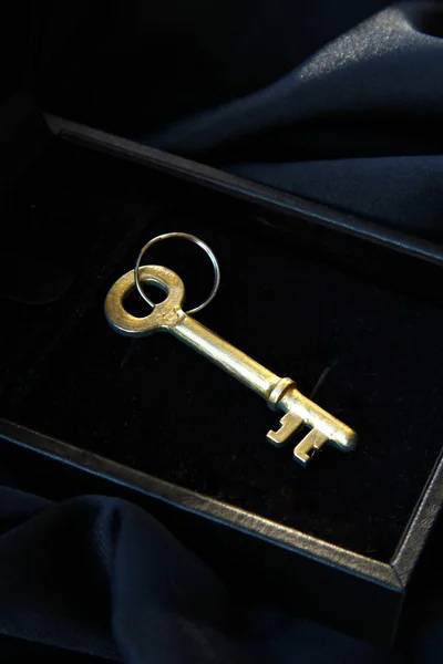 Siyah bir arka plan üzerinde siyah kutusundaki Vintage altın anahtar — Stok fotoğraf
