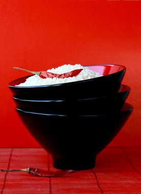 siyah bir kase chili biber kırmızı zemin üzerine beyaz pirinç