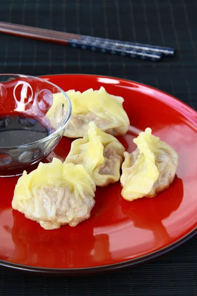 Chinesisches Essen - Dim Sum auf rotem Teller mit Essstäbchen — Stockfoto