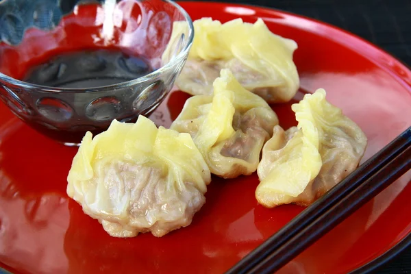 Comida chinesa - soma escura em chapa vermelha com pauzinhos — Fotografia de Stock