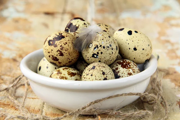 Quail eggs in a bowl on a wooden table — Stock Photo, Image