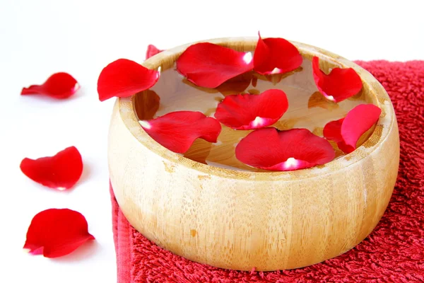 Концепция спа с лепестками роз и красным полотенцем — стоковое фото