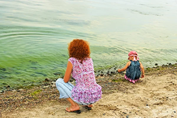 Mother and daughter on the bank — Stock Photo, Image