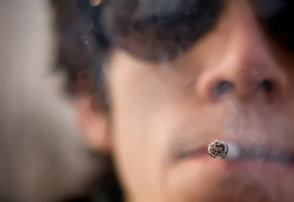Caucásico hombre sosteniendo 1 cigarro en su boca . — Foto de Stock