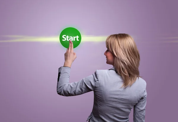 Женщина вручную нажимает зеленую кнопку START — стоковое фото