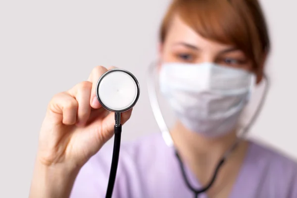Vrouwelijke arts houden stethoscoop wees naar camera — Stockfoto