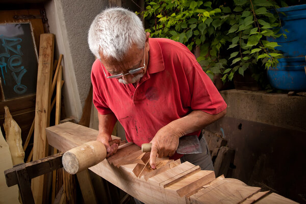 Woodcarver working with mallet and chisel 7