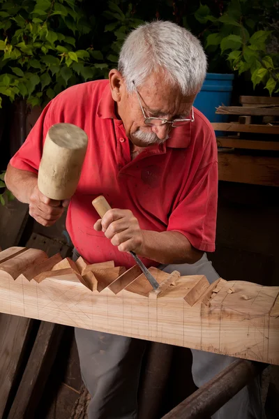 Резчик по дереву, работающий с молотком и зубилом — стоковое фото