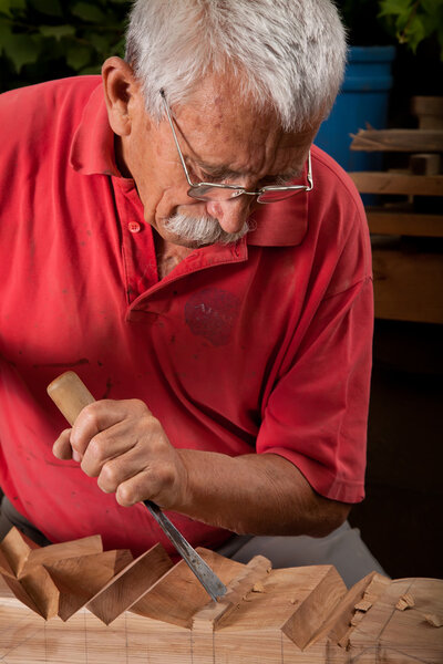 Woodcarver working with mallet and chisel