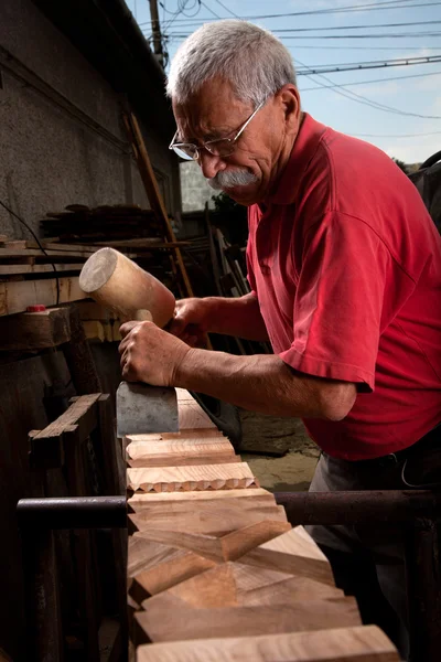 Alter Holzschnitzer arbeitet mit Holzhammer — Stockfoto