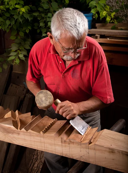 Old woodcarver working with mallet — Stock Photo, Image