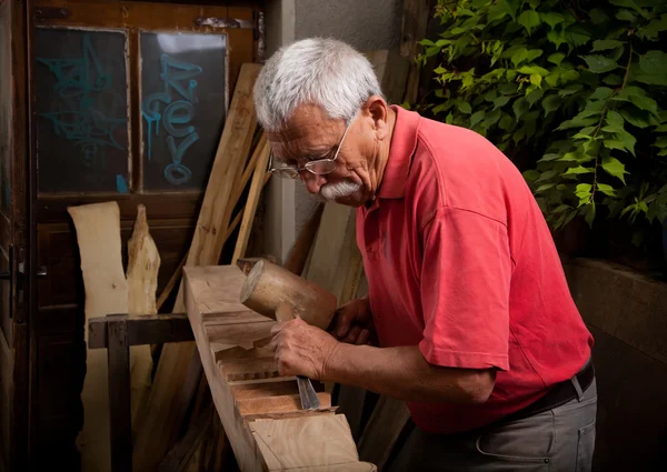 Vieux sculpteur sur bois travaillant avec maillet — Photo