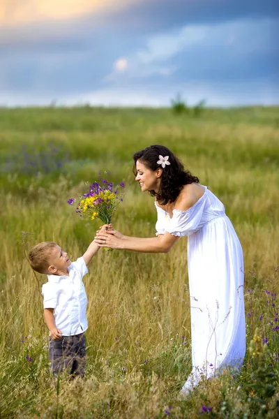Son gives mom flowers — Stock Photo, Image