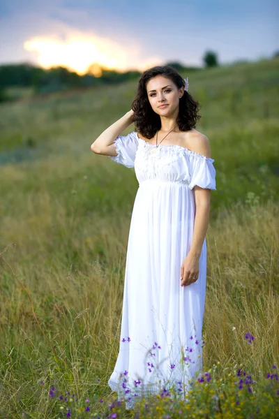 Молодая девушка стоит в поле — стоковое фото