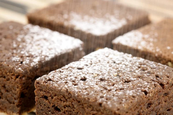 stock image Chocolate brownies being sprinkled powdered sugar