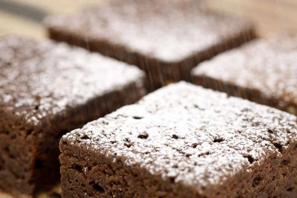 Шоколадные пирожные посыпают сахарной пудрой — стоковое фото