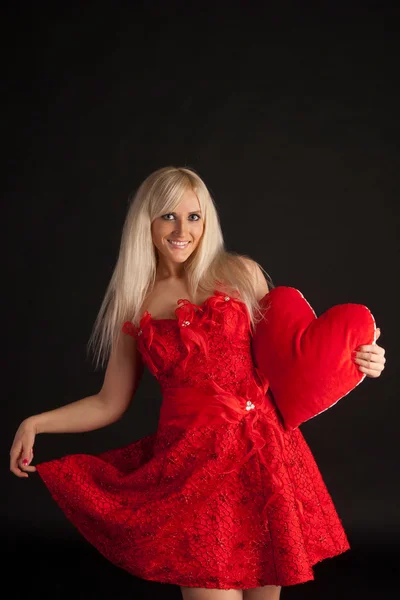 Atraktivní žena kousání červené srdce — Stock fotografie