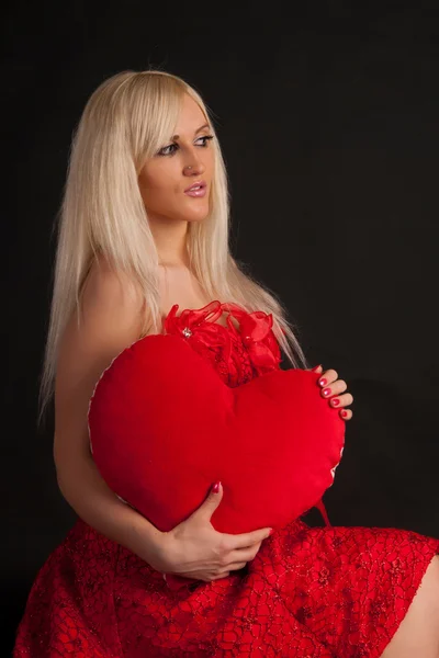 Attraktive Frau beißt in ein rotes Herz — Stockfoto