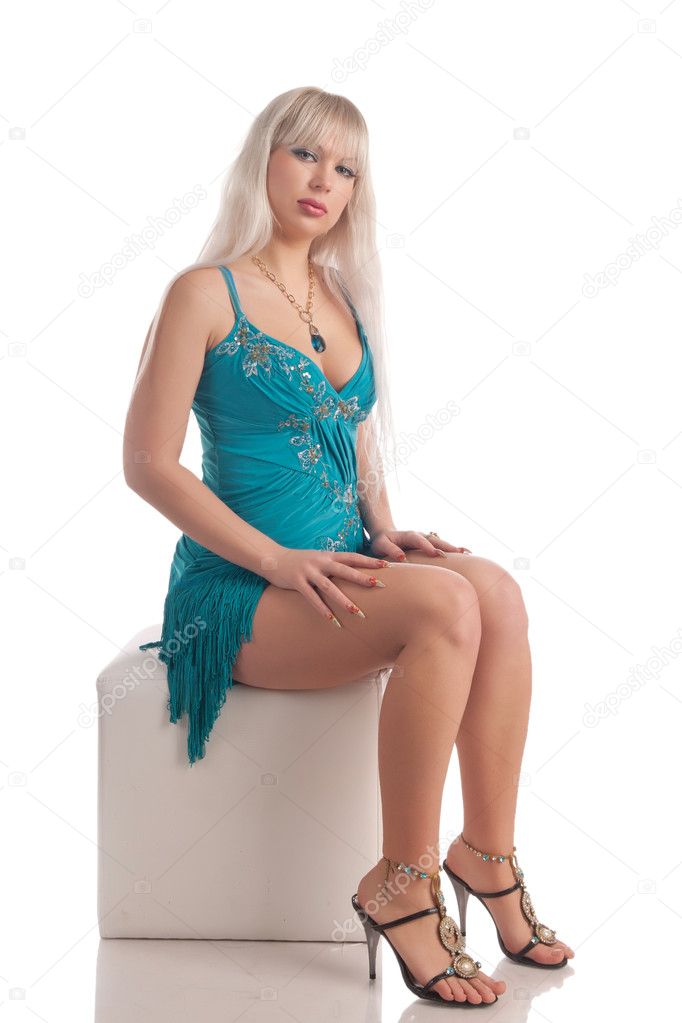 Beautiful girl sits on a cube