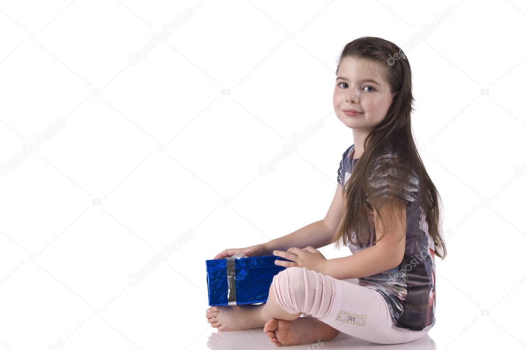 Little girl sitting on the floor with a blue gift box