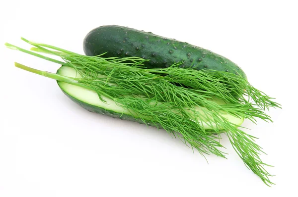 A cucumber with the cut half lying on a dill — Stock Photo, Image