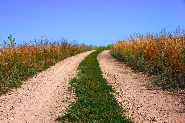 Сельская дорога и голубое небо — стоковое фото