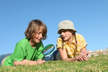 Kids playing outdoors with magnifying, glass clipart