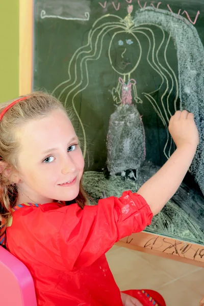 Happy artistic, kid, drawing on blackboard in class or home — стоковое фото