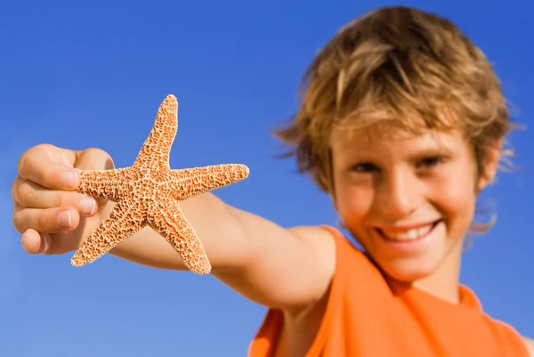 Летний ребенок фокусируется на морской звезде — стоковое фото