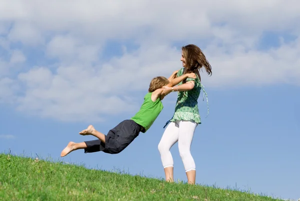 Jovem mãe brincando ao ar livre com a criança no verão — Fotografia de Stock