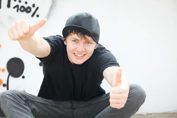 Gelukkig tiener met thumbs up voor succes — Stockfoto