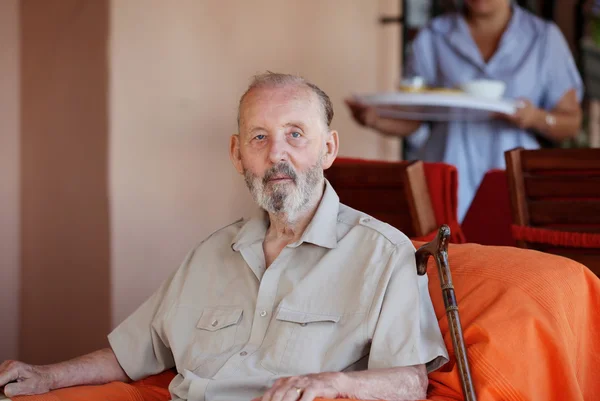 Senior äldre man med vårdare som serverar måltid — Stockfoto
