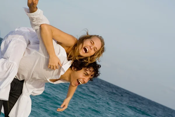 Lyckliga piggyback paret på vårlovet eller sommarsemester — Stockfoto
