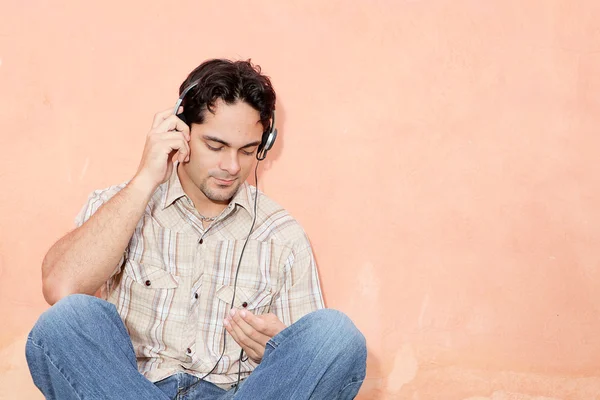 Hombre escuchando música con auriculares y estéreo personal — Foto de Stock
