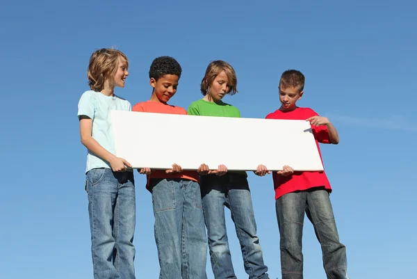 Skupina různorodých dětí drží prázdné bílé plakát — Stock fotografie