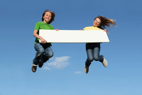 Niños saltando sosteniendo cartel en blanco — Foto de Stock